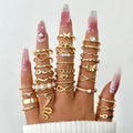 Multiple gold rings on fingers with a plain background