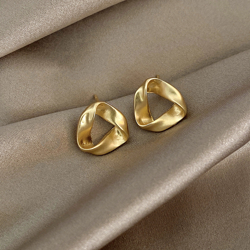 Gold hoop earrings on beige fabric