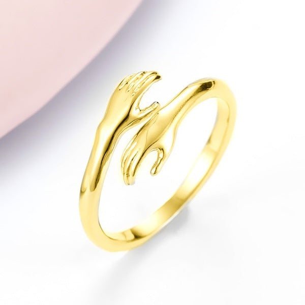 Gold and silver open hand-shaped rings on a white background