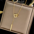 Gold necklace with geometric pendants on a brown jewelry box