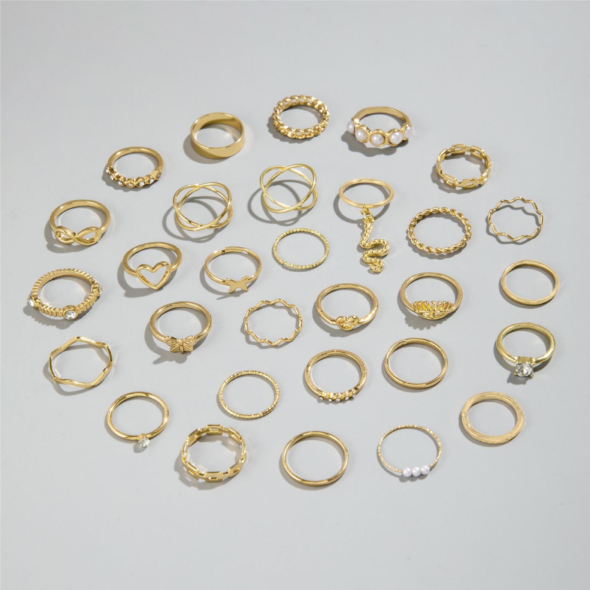 Collection of gold rings on a light gray background