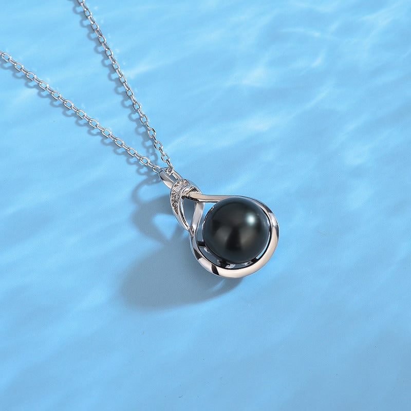 Pearl necklace with a black pearl on a blue background