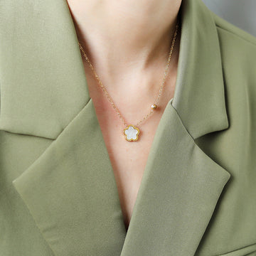 Necklace with a star-shaped pendant worn by a person in a green outfit.