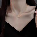 Gold necklace being worn by a person against a dark background