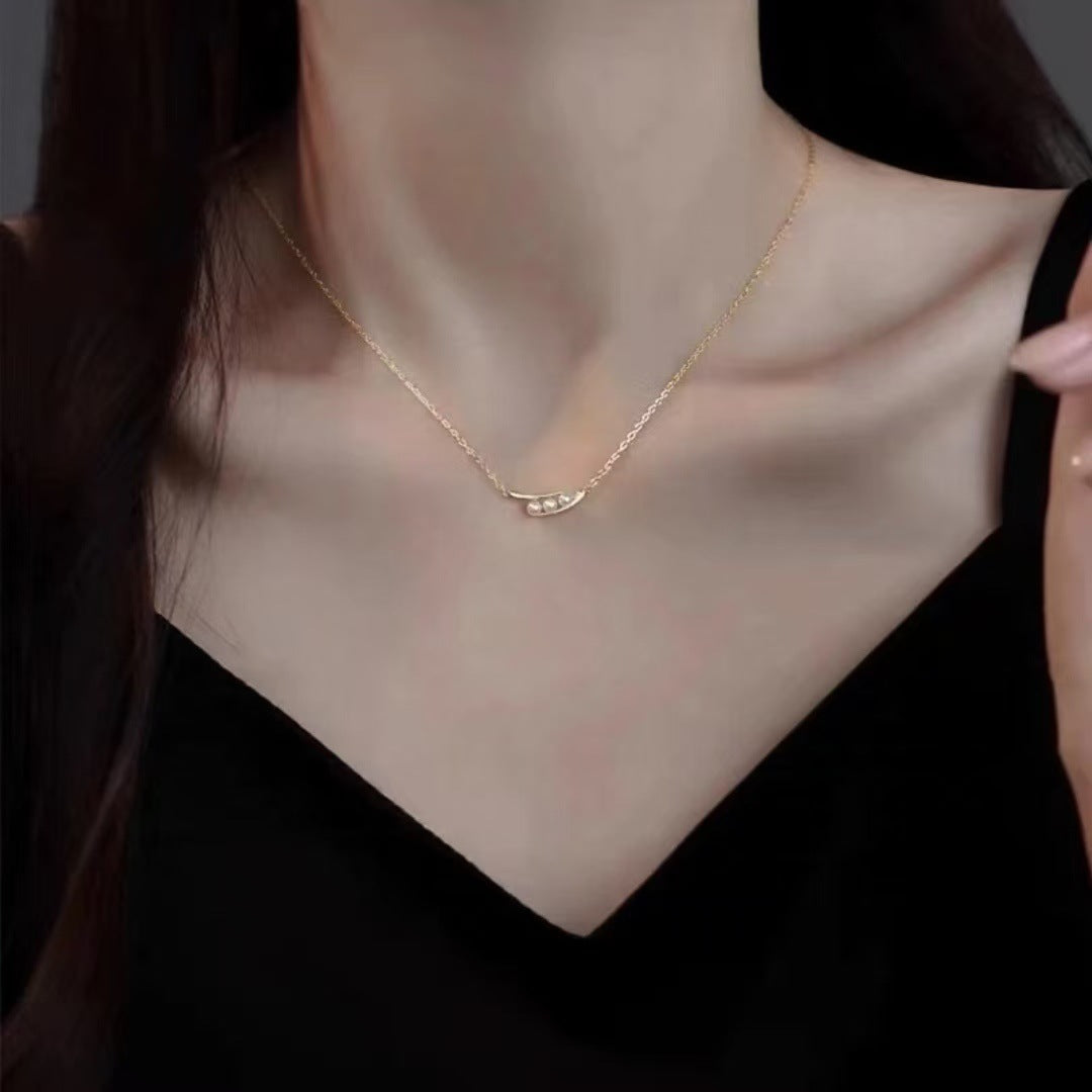 Gold necklace being worn by a person against a dark background