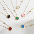 Colorful flower-shaped pendant necklaces on gold chains against a white background