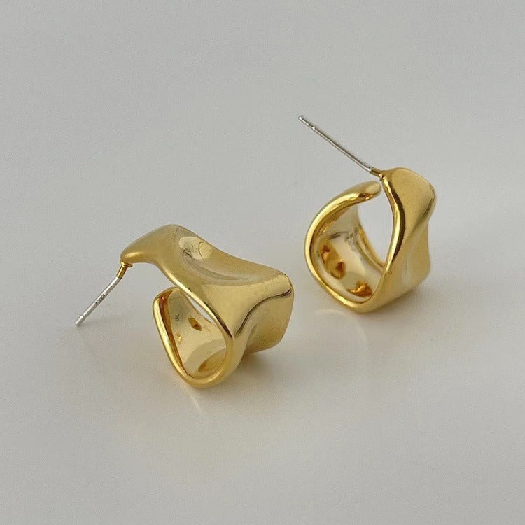Pair of gold hoop earrings on a light gray background