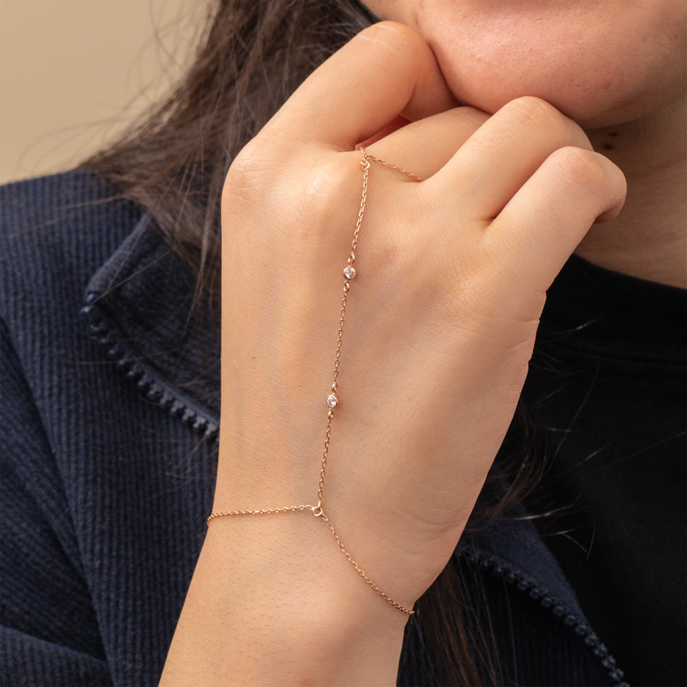 Rose gold bracelet on a person's wrist with a neutral background