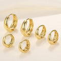 Set of gold hoop earrings on a light background