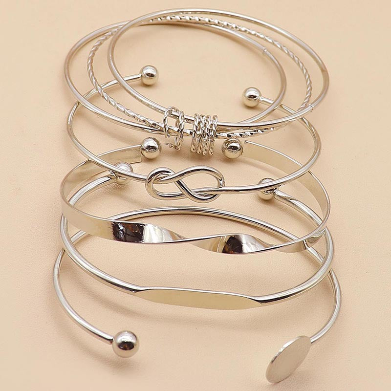 Set of silver bangles on a beige background