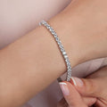 Silver bracelet on a wrist with a soft pink background