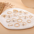 Collection of gold rings with gemstones on a white stone surface.