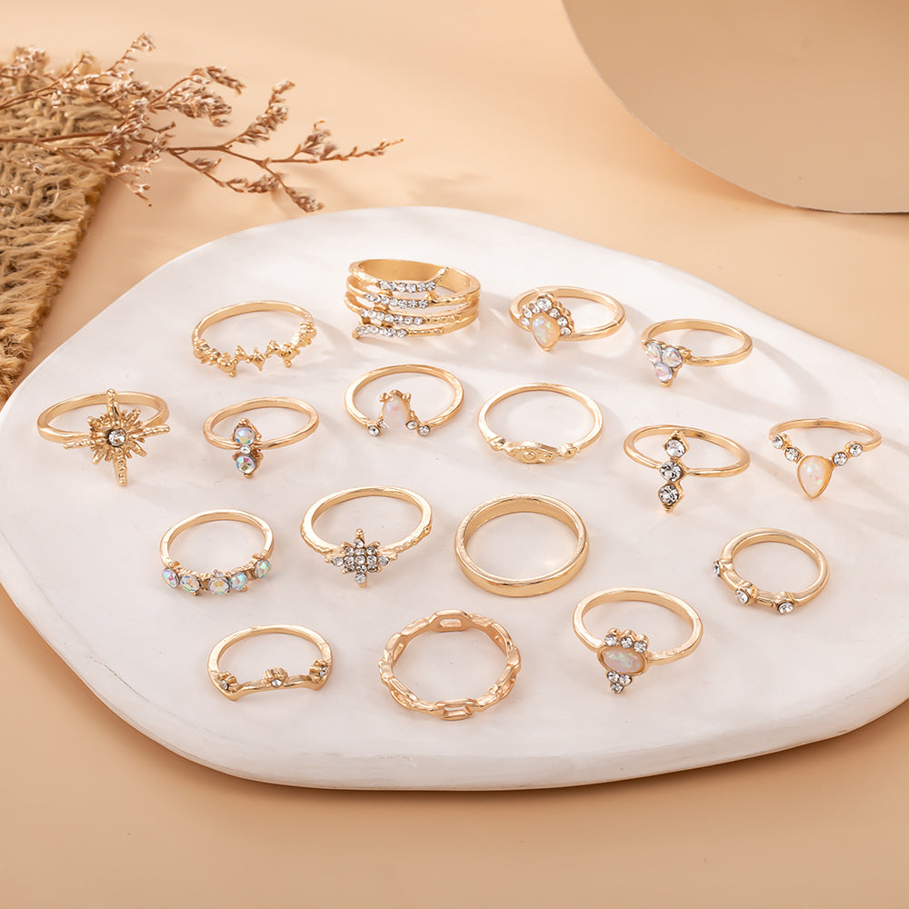 Collection of gold rings with gemstones on a white stone surface.