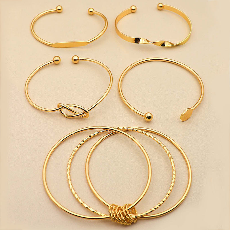 Gold bracelet with intricate design on a beige background