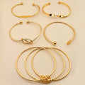 Set of gold bracelets on a beige background