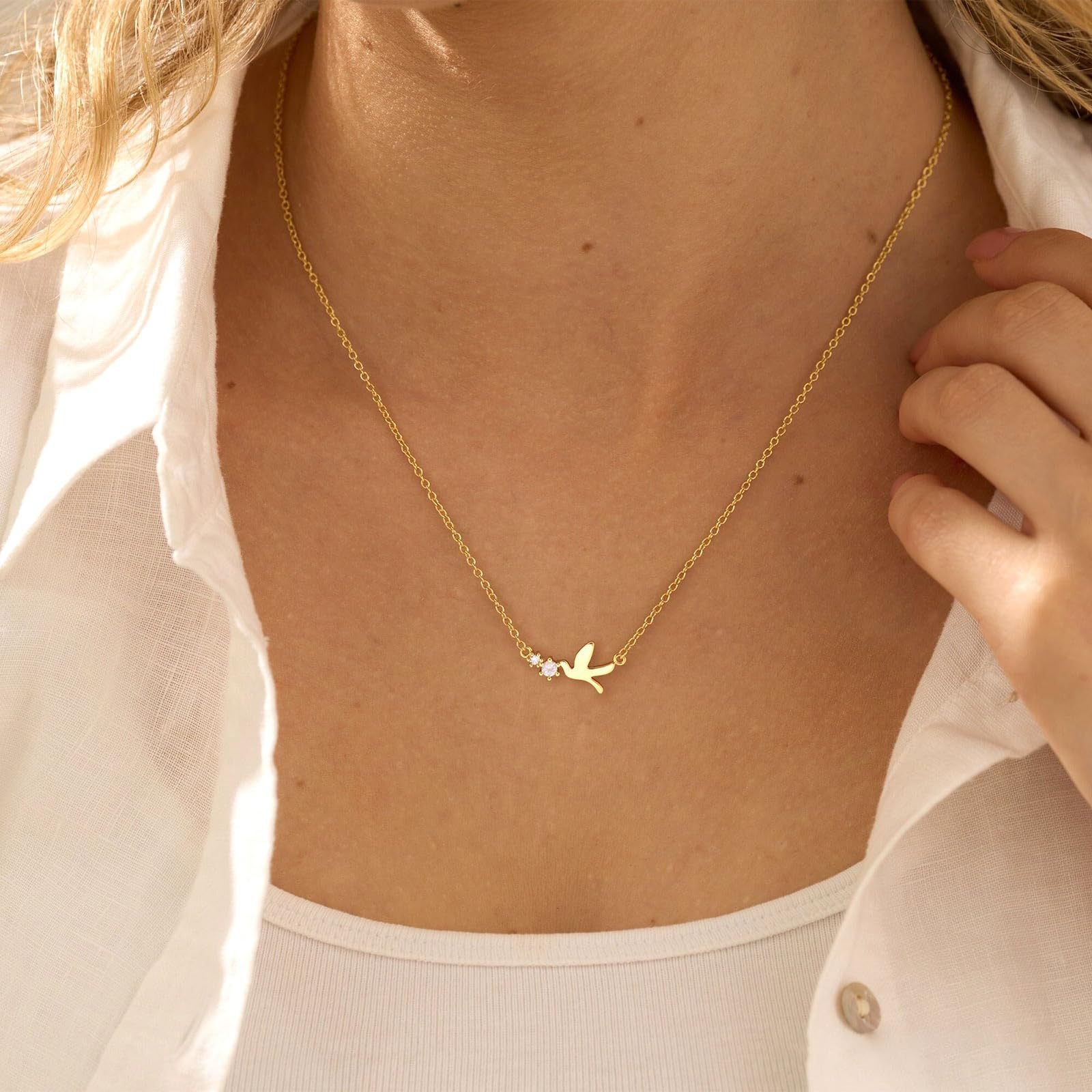 Gold necklace with a delicate pendant worn by a person