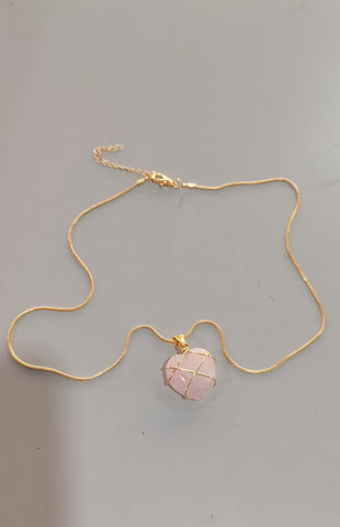 Necklace with a pink stone pendant on a gray background