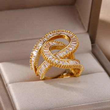 Gold and diamond ring on a beige cushion in a jewelry box