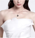 Woman wearing a white off-shoulder top and a necklace with a pendant.