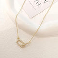 Gold necklace with a heart-shaped pendant on a light background