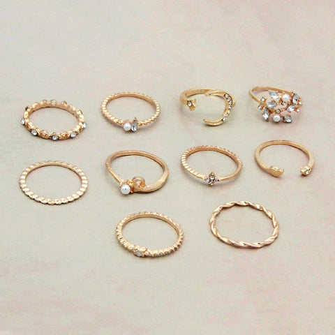 Collection of gold rings with various designs on a light background