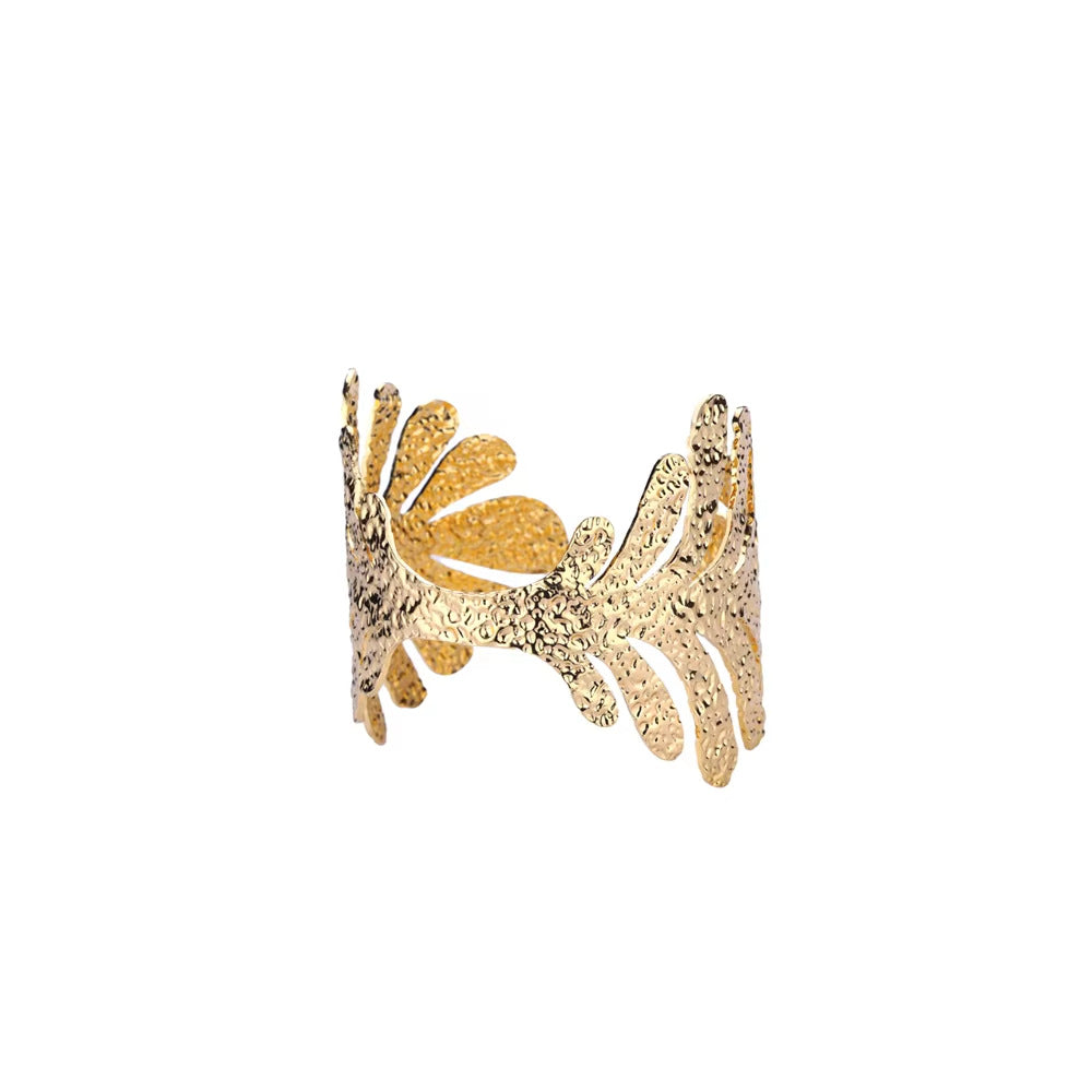 Gold ring with intricate design on a white background