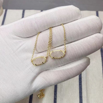 Gold necklaces on a hand wearing a white glove with a striped fabric background