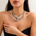 Woman wearing a silver necklace against a neutral background
