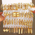 Assorted gold hoop earrings on a display card held by a hand.