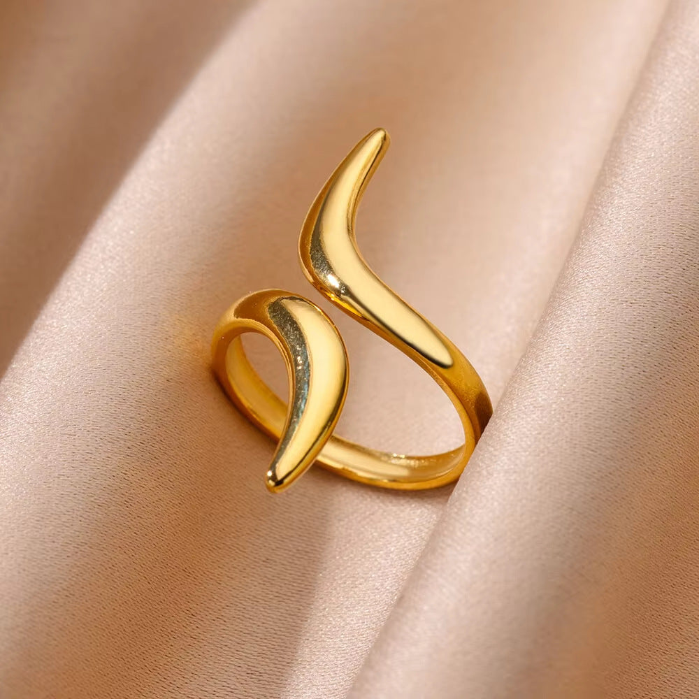 Gold ring with a unique design on a beige fabric background