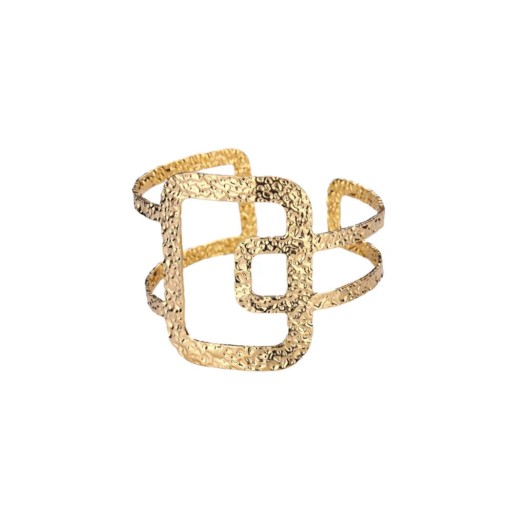 Gold bracelet with textured design on a white background