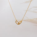 Gold necklace with a heart-shaped pendant on a light background