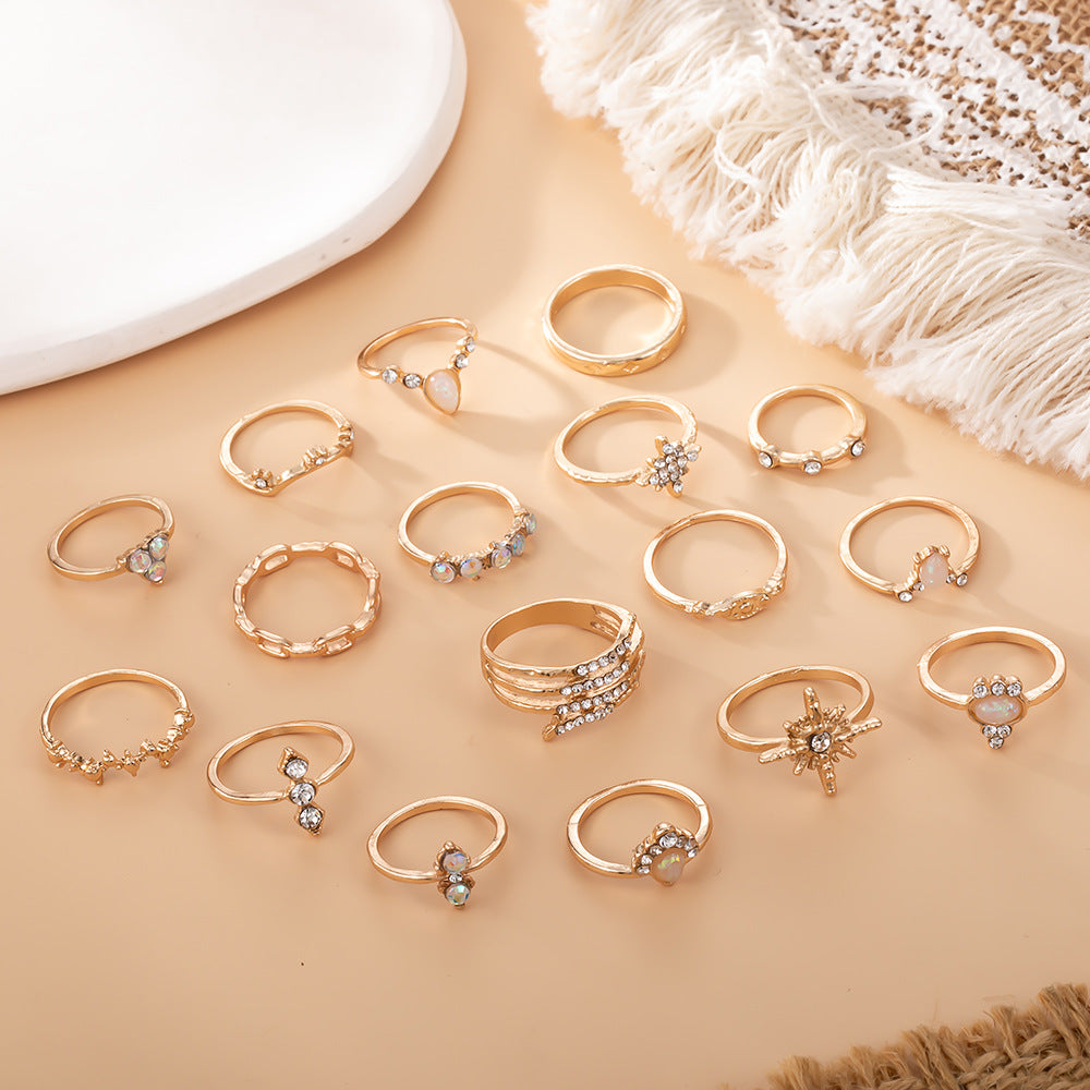 Collection of gold rings with gemstones on a beige surface