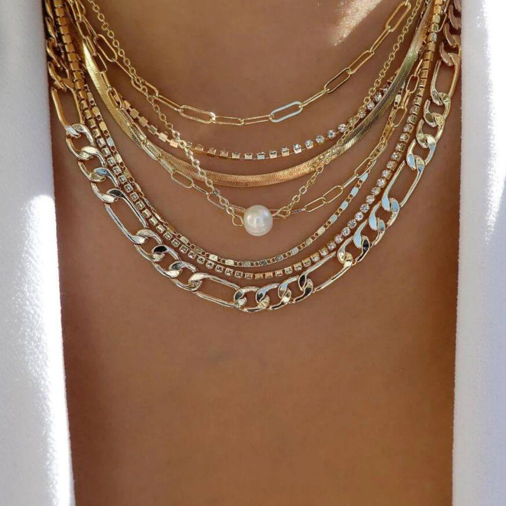 Multiple gold chains with a pearl on a mannequin neck
