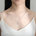 Necklace with a pendant worn by a model in a white top