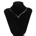 Necklace on a black velvet mannequin bust against a white background