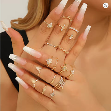 Hand wearing multiple gold rings with a blurred background